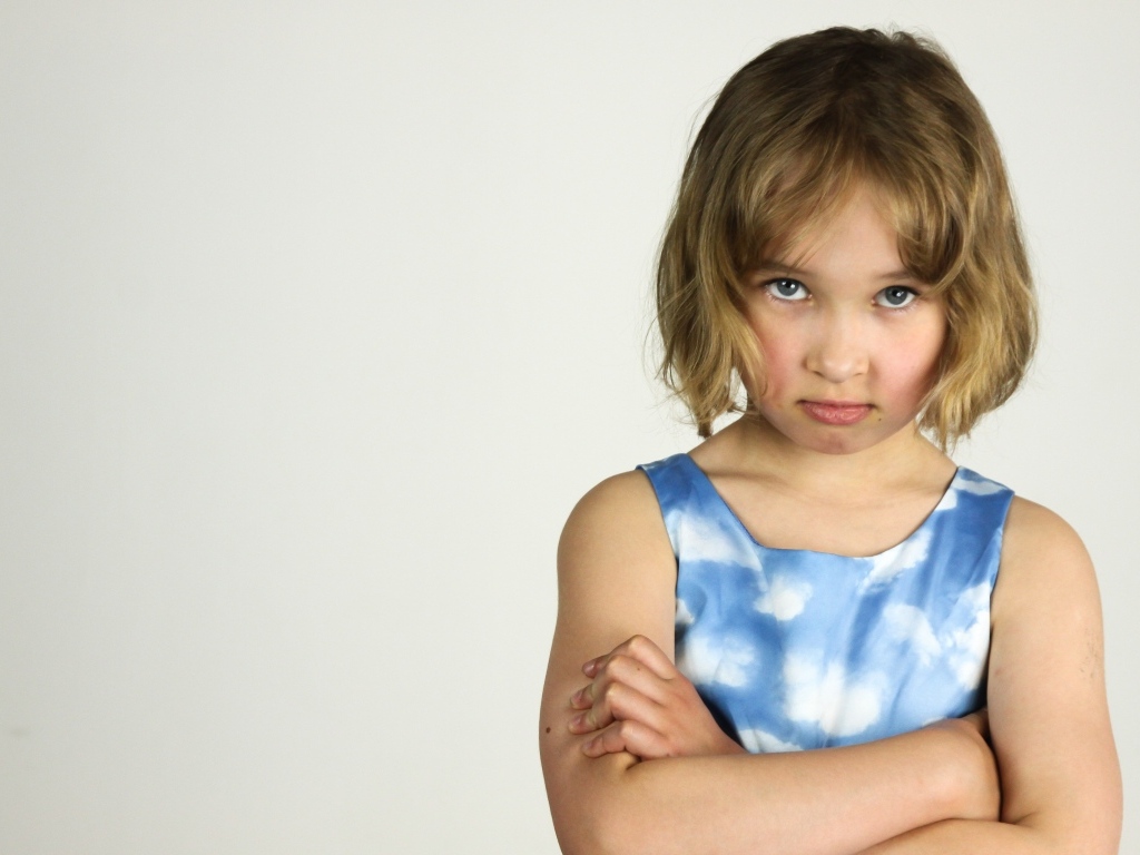 Серьезная девочка на сером фоне