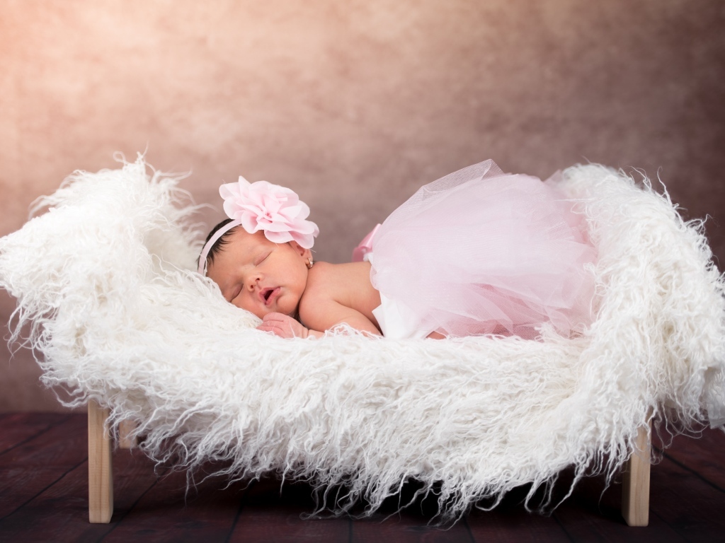 Спящая новорожденная девочка в пышной юбке