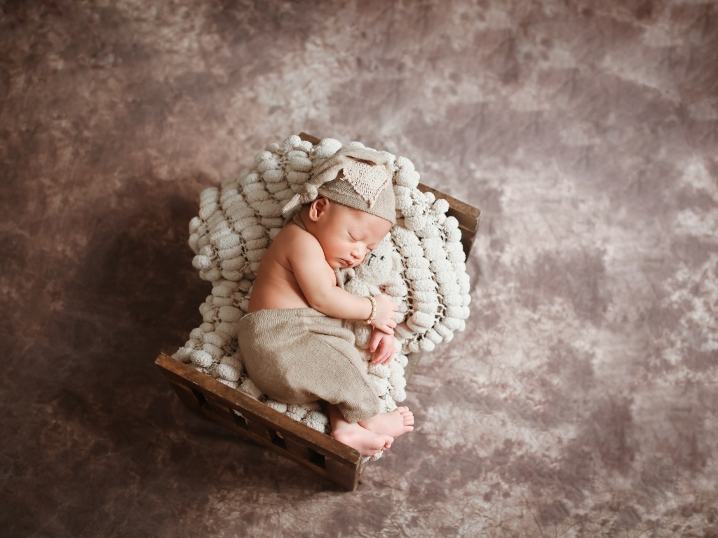 Спящий новорожденный ребенок в кроватке 