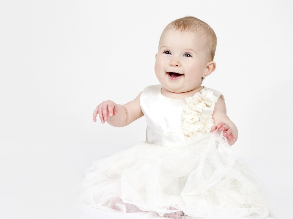 Улыбающаяся маленькая девочка в белом платье 