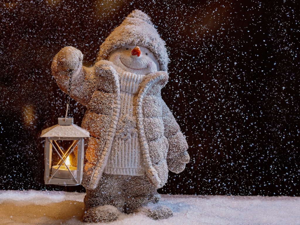 Игрушечный снеговик с фонариком в снегу