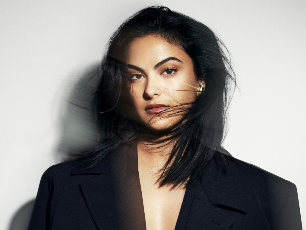 Стильная актриса Камила Мендес в черном пиджаке на сером фоне