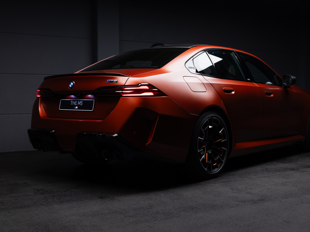 Вид сзади на красный автомобиль BMW M5 2025 года