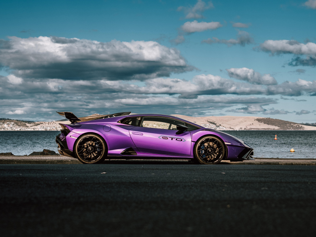 Вид сбоку на автомобиль Lamborghini Huracan STO на фоне неба