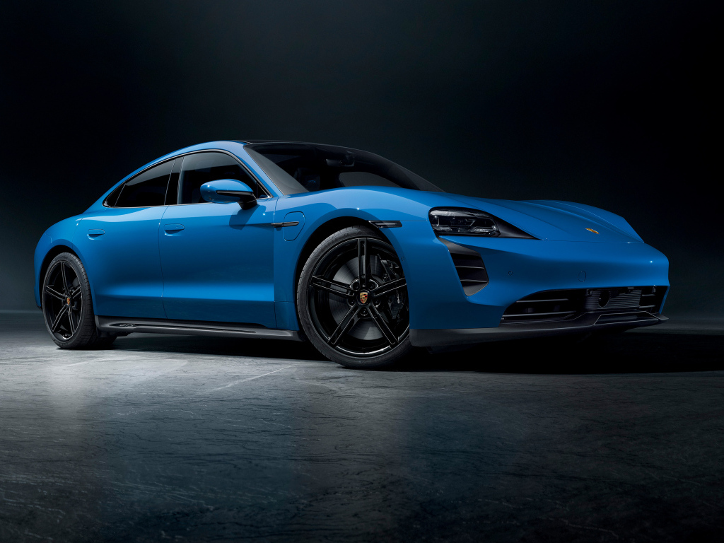 Синий автомобиль Porsche Taycan GTS на черном фоне
