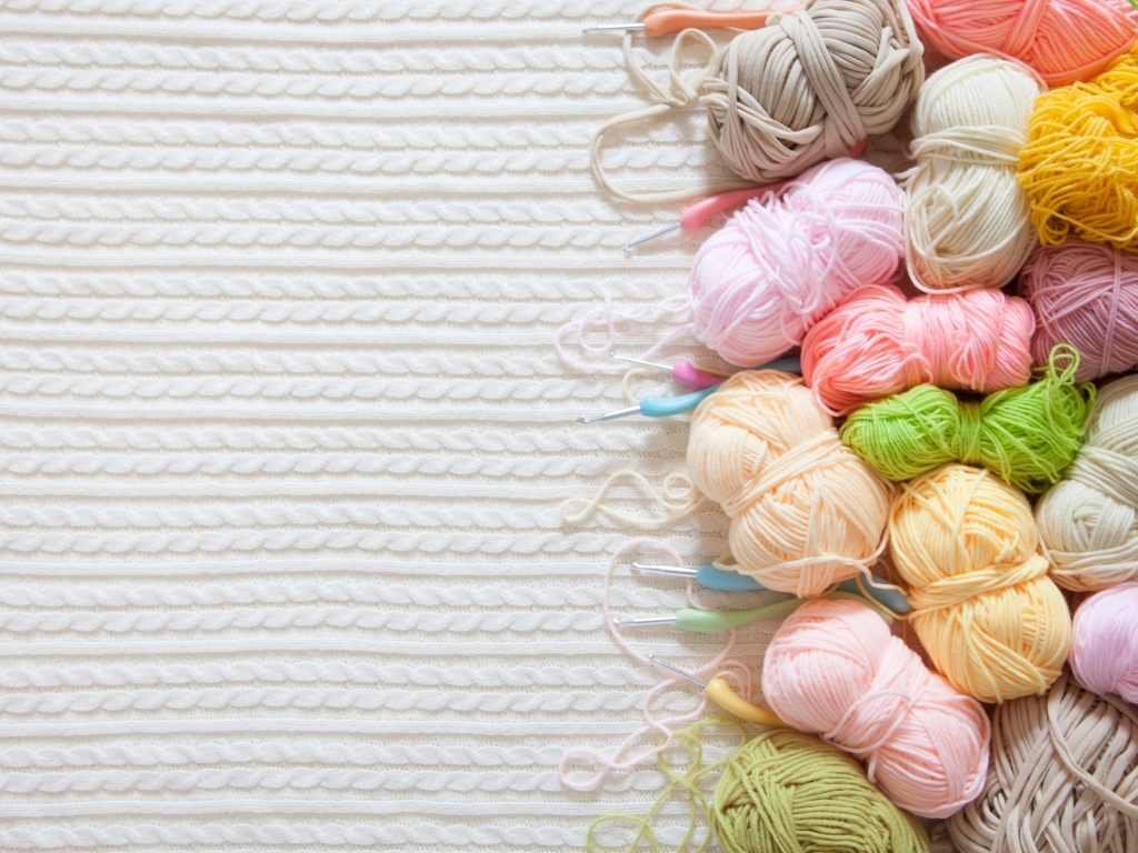 Разноцветная пряжа для вязания на белом трикотажном полотне