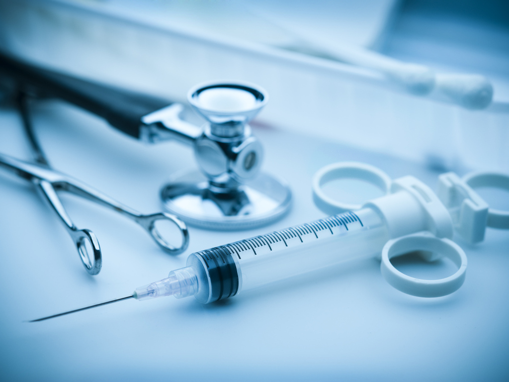 Шприц, зажим  и стетоскоп на столе