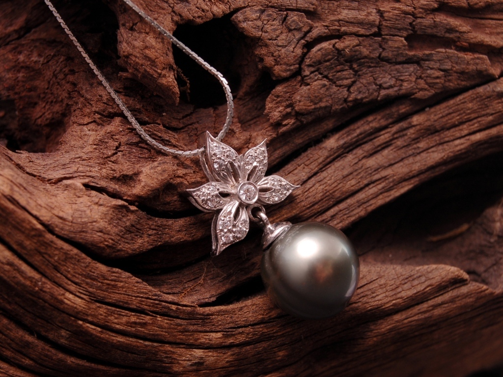 Кулон на цепочке лежит на старом дереве