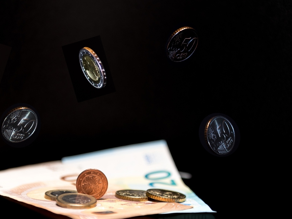 Купюры с монетами на черном фоне