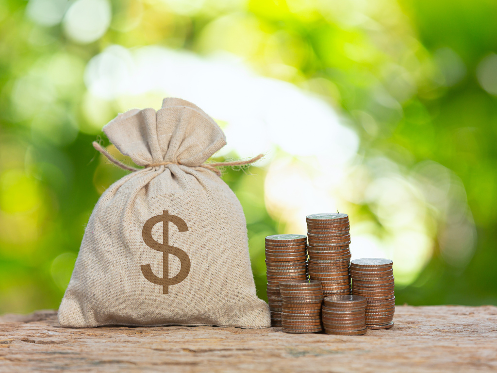 Мешок с деньгами на столе с монетами