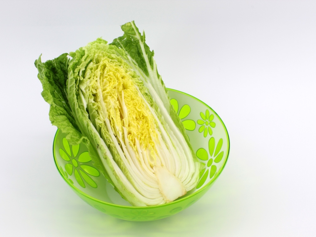 Пекинская капуста в миске на сером фоне