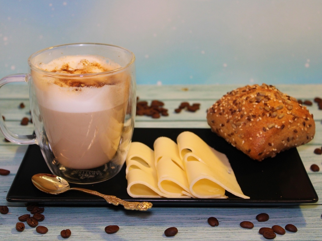 Кофе на тарелке с булочкой и кусочками сыра