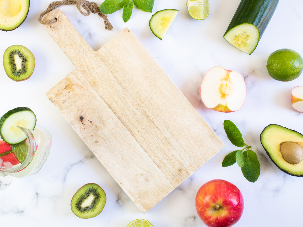 Разделочная доска с фруктами и овощами на столе