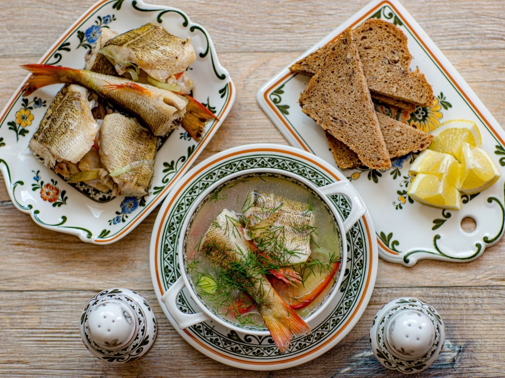 Уха на столе с хлебом и лимоном