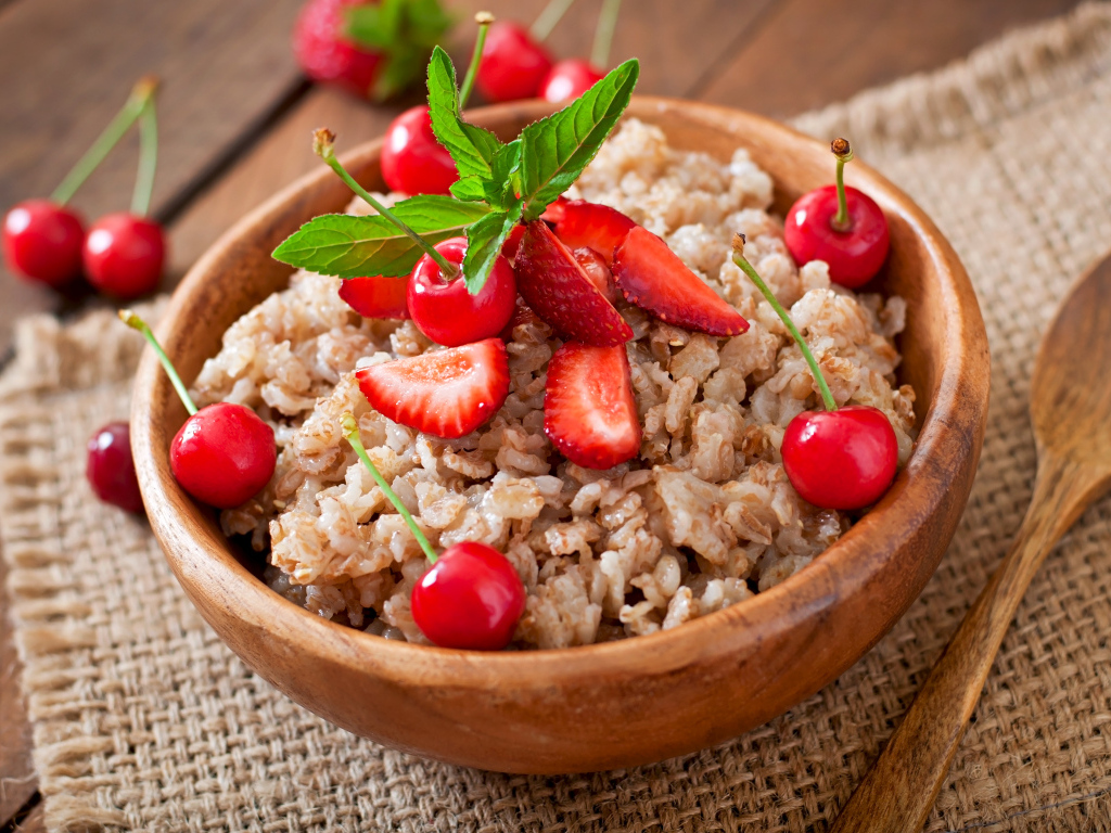 Овсяная каша с ягодами в деревянной миске