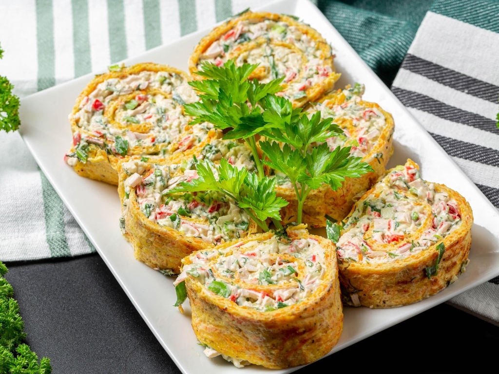 Рулет с омлета с начинкой на тарелке