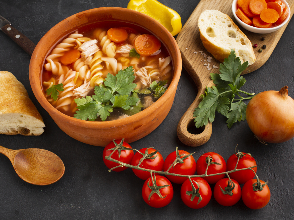 Макароны в тарелке на столе с овощами и специями