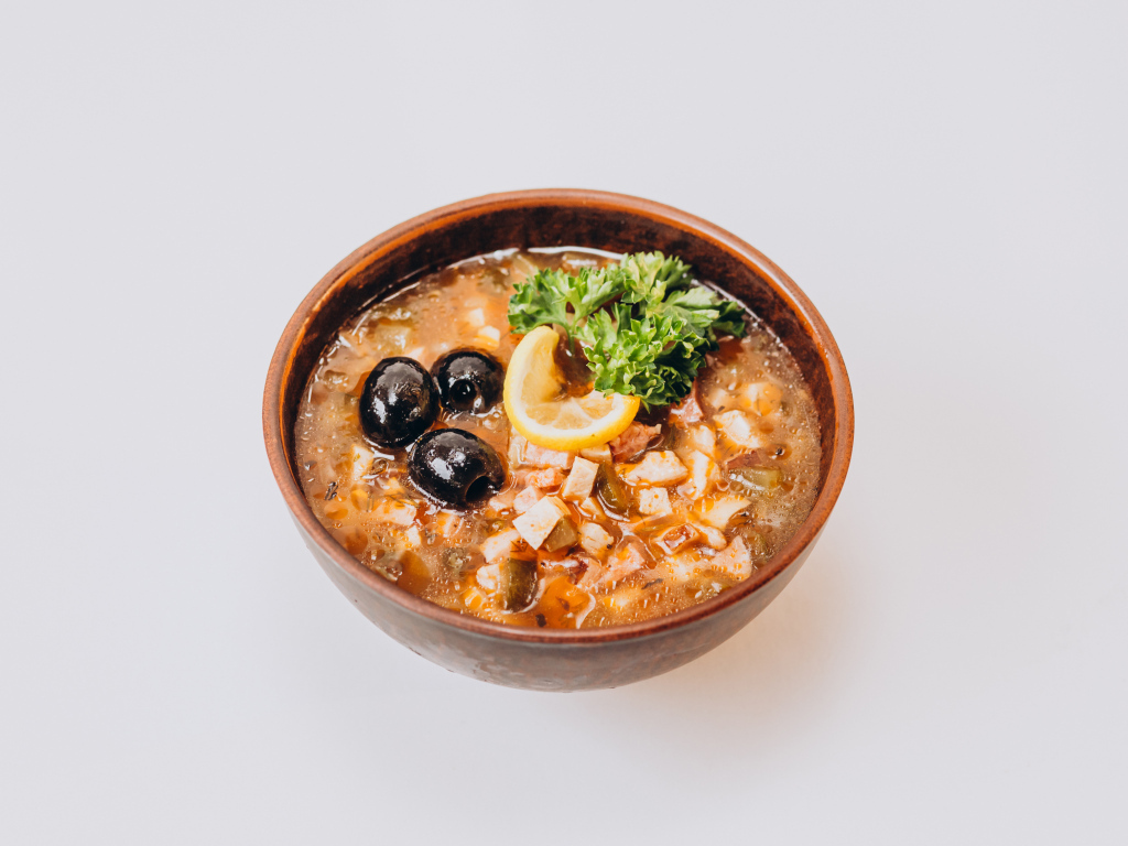 Солянка в тарелке на сером фоне