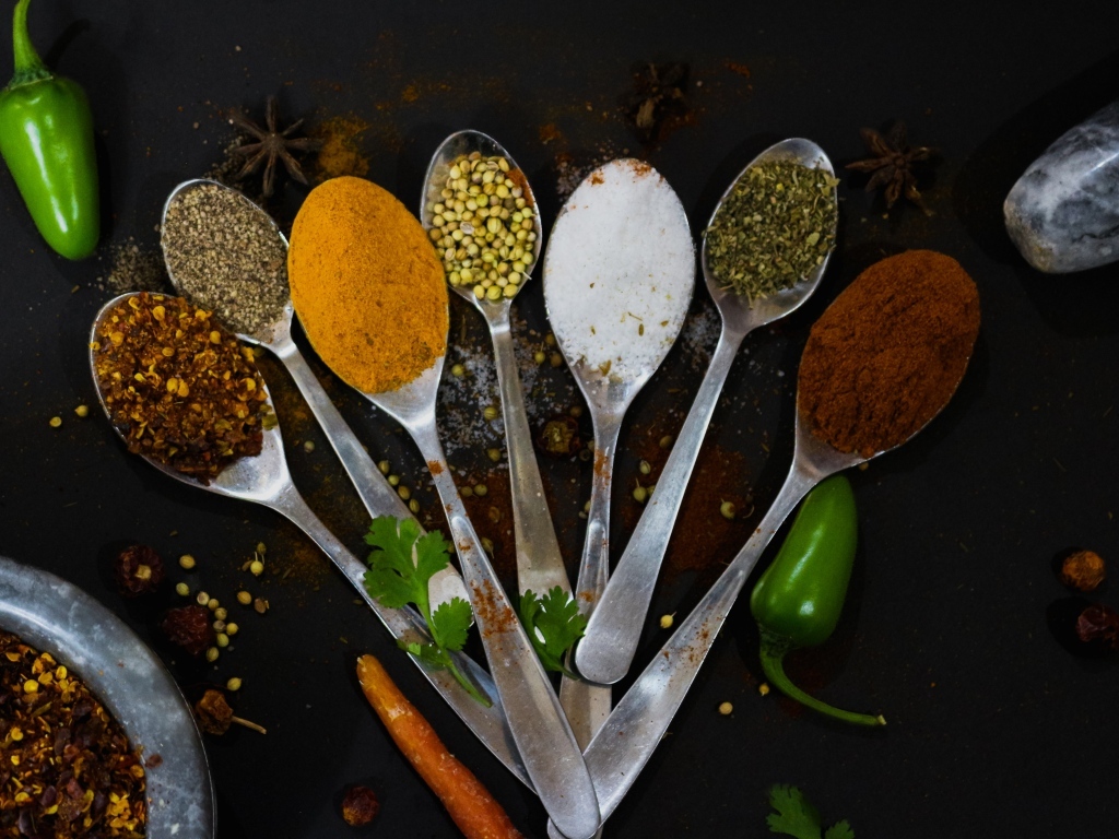Ложки с ароматными специями на черном столе