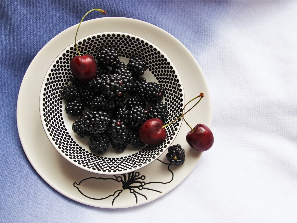 Ягоды ежевики и черешни на столе