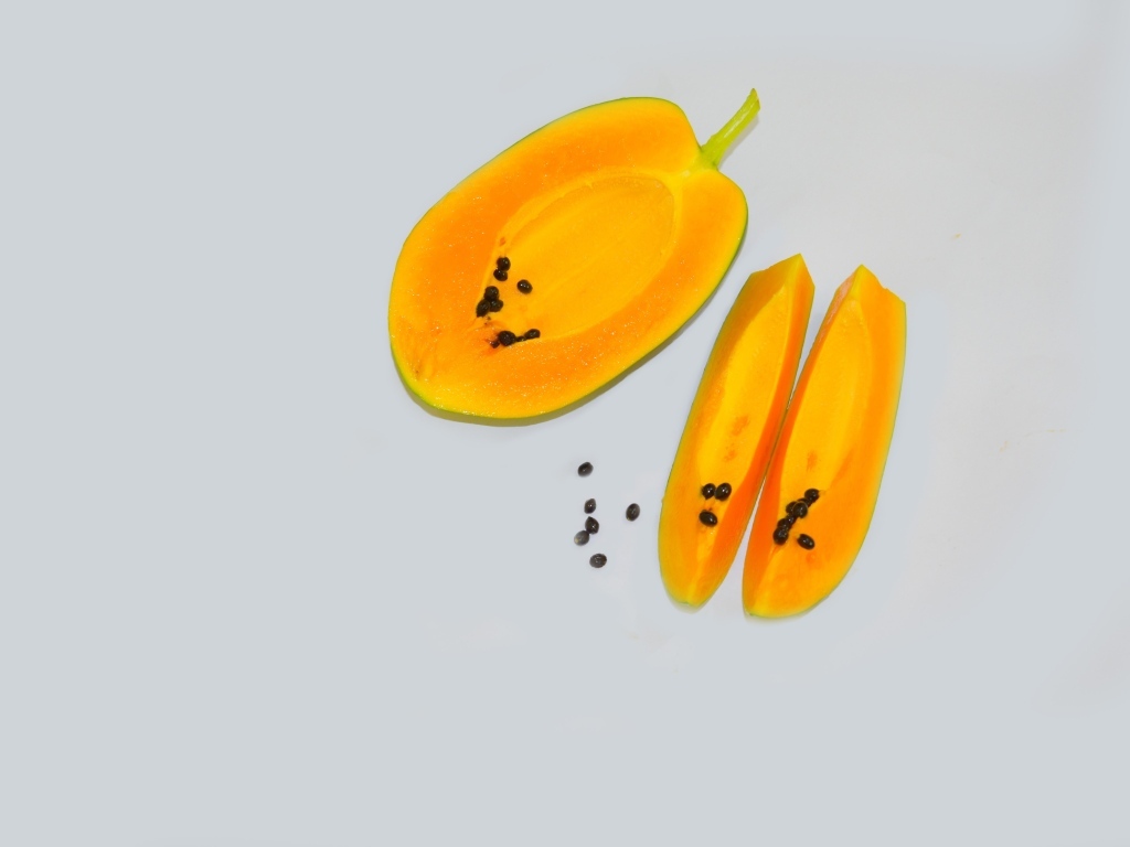 Разрезанная папайя на сером фоне