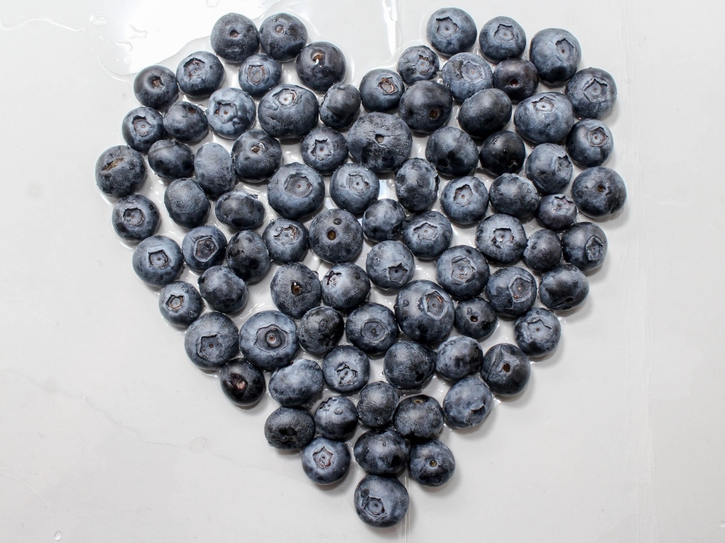 Сердце из ягод черники на сером столе