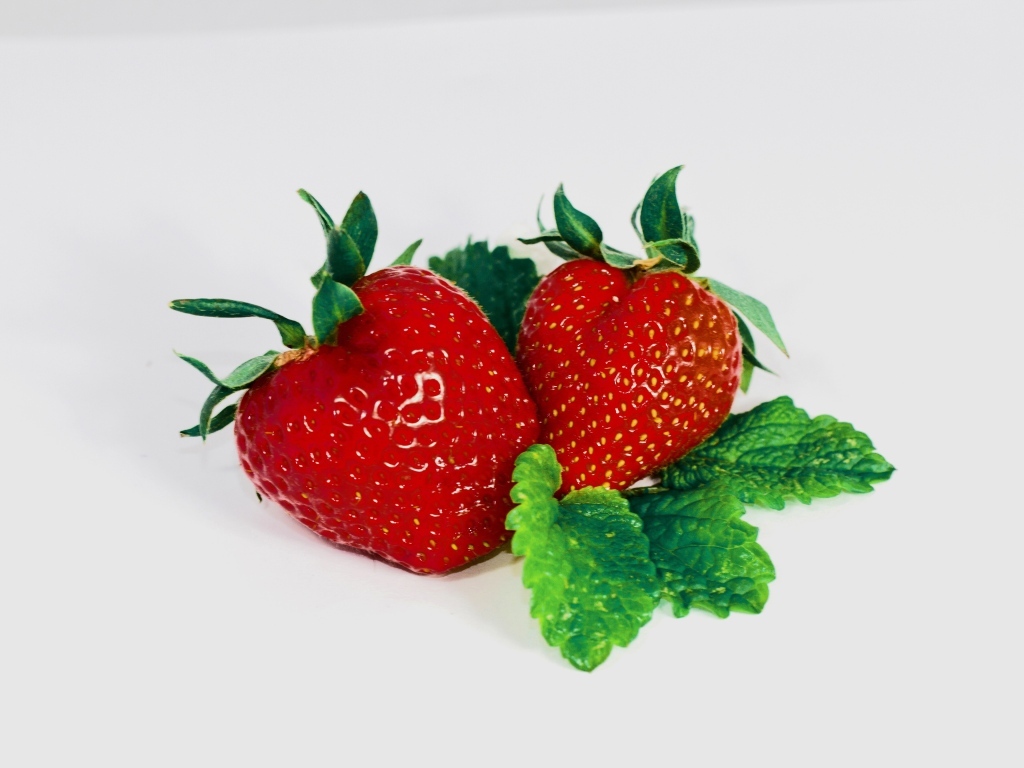 Красная клубника с листьями мяты на сером фоне