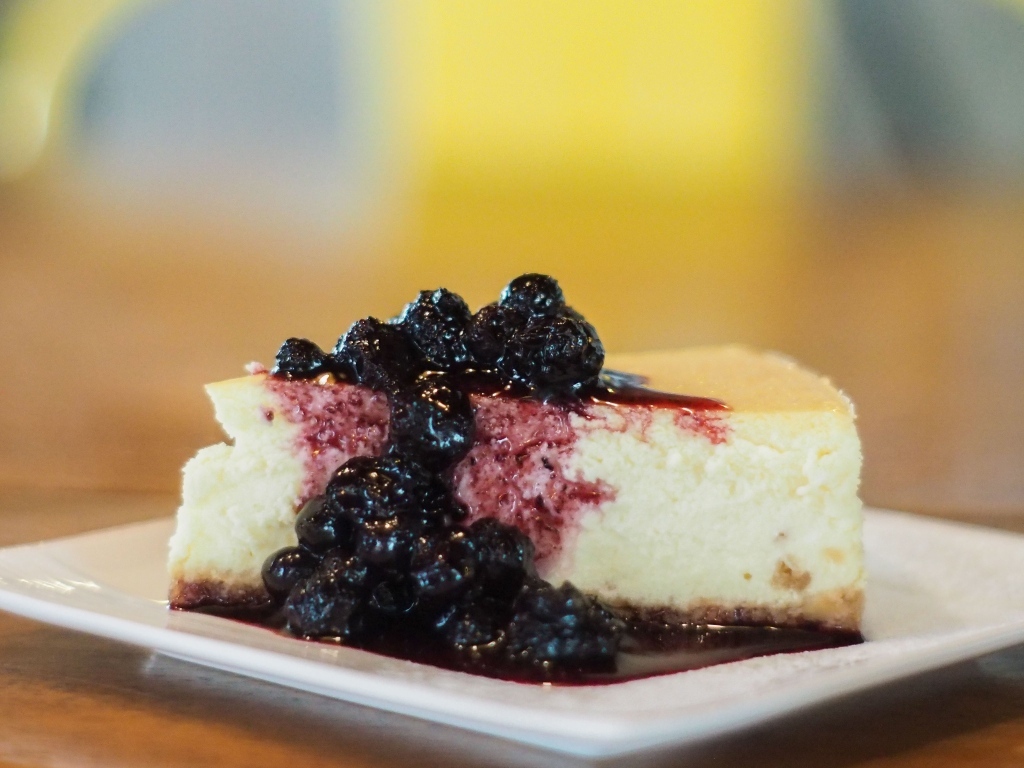 Кусок чизкейка с черничным вареньем