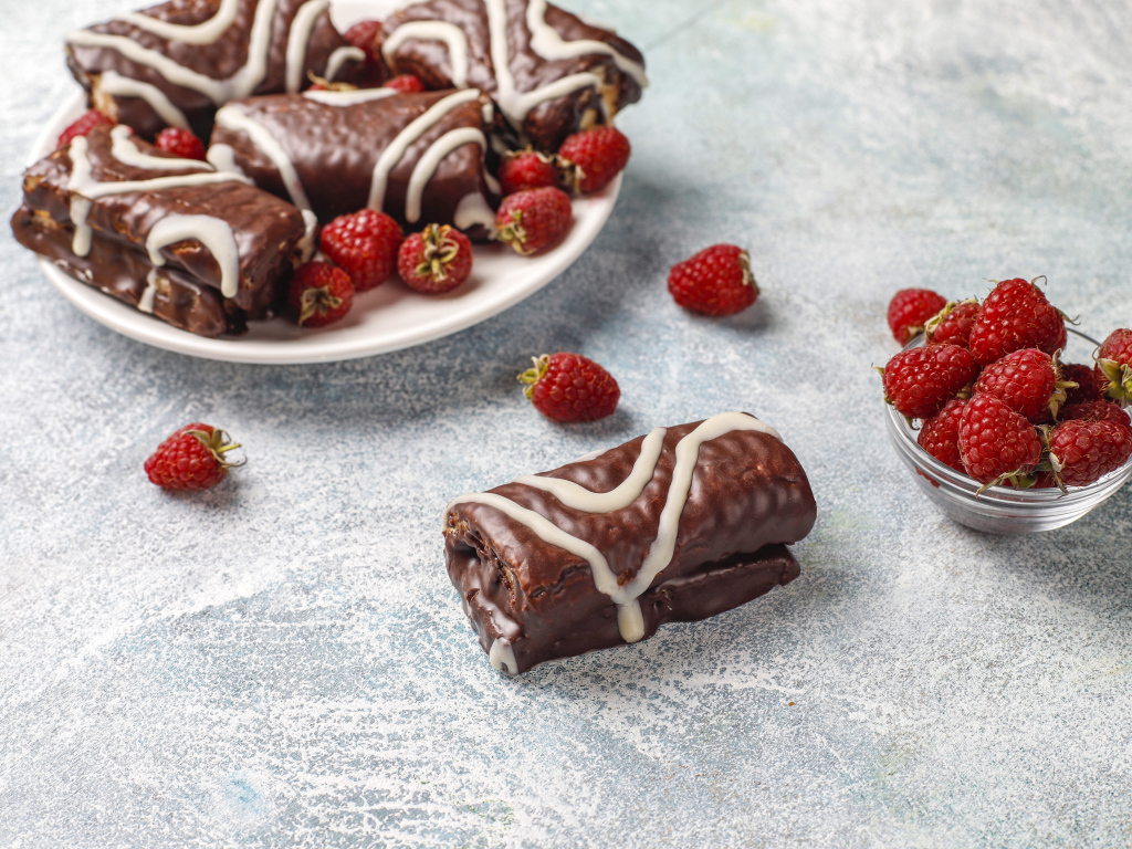 Шоколадные рулетики с ягодами малины на столе