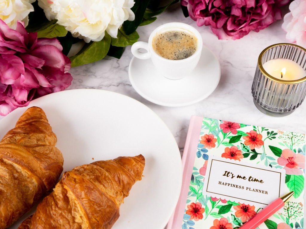 Круассаны на столе с кофе и цветами