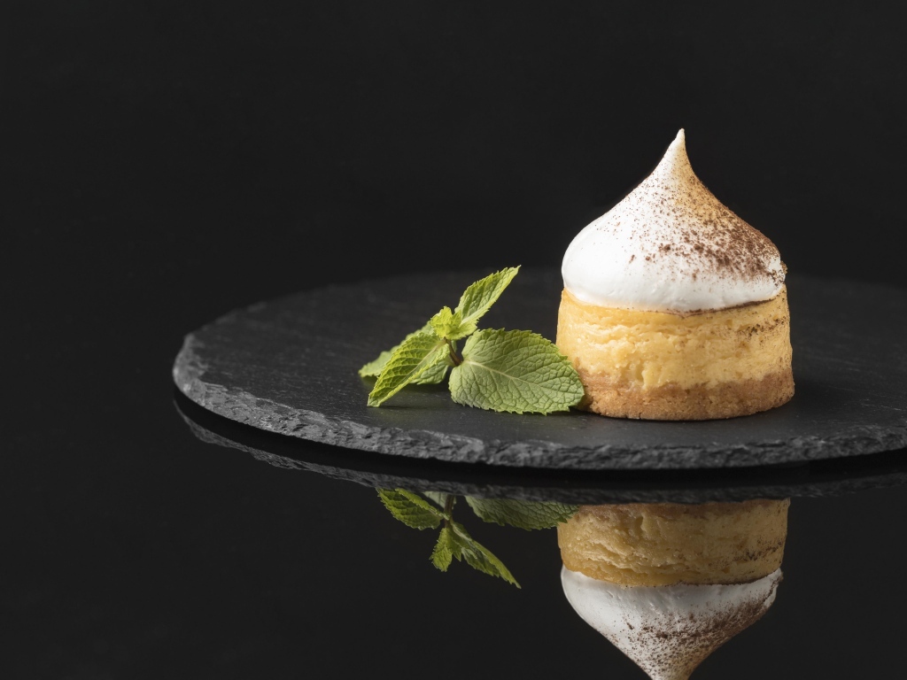 Десерт с кремом и листьями мяты на черном фоне