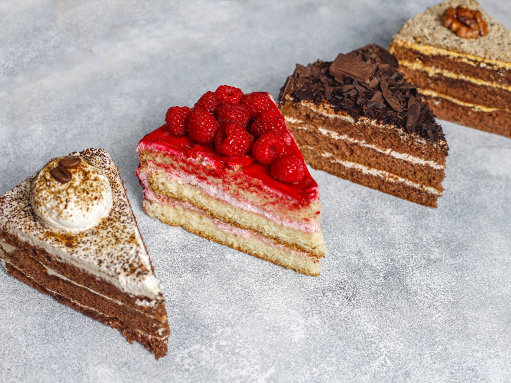 Четыре разных вкусных куска торта на столе