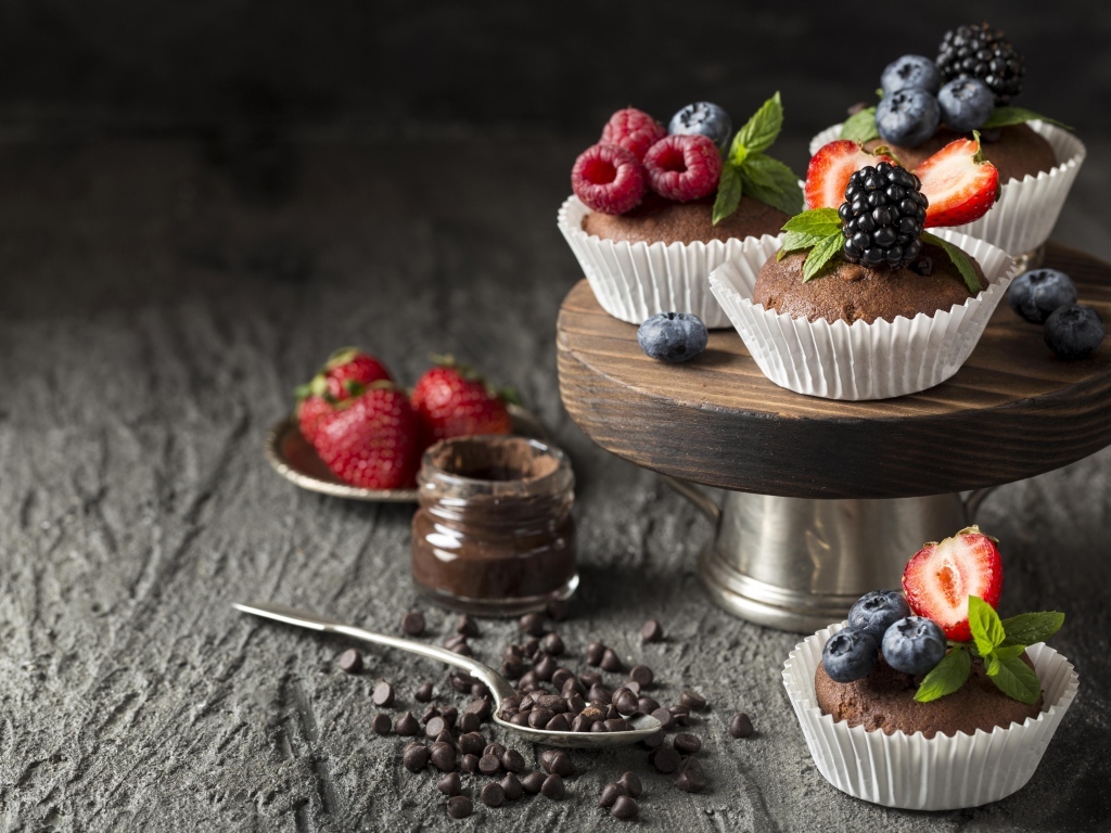 Кексы со свежими ягодами на столе с шоколадом