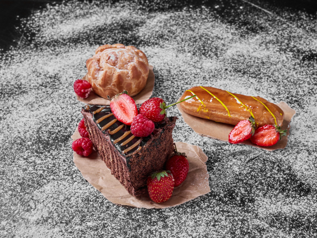 Кусок торта с ягодами на столе с эклером