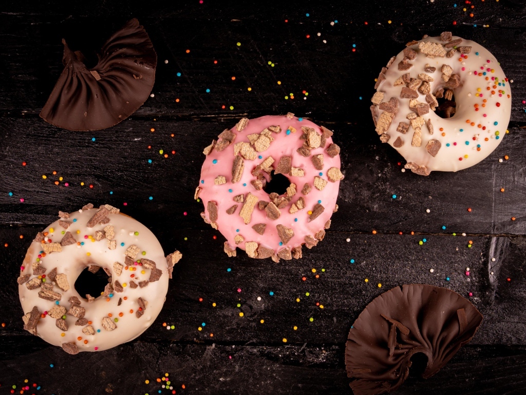 Три сладких пончика на черном столе