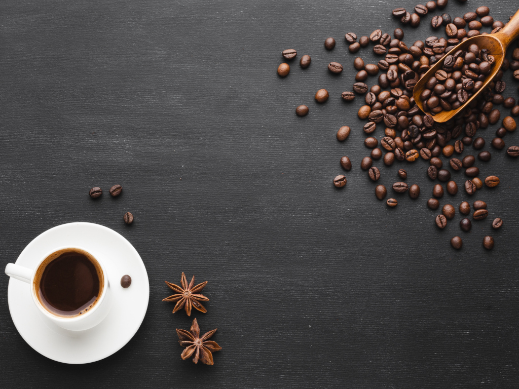 Чашка кофе на черном столе с зернами