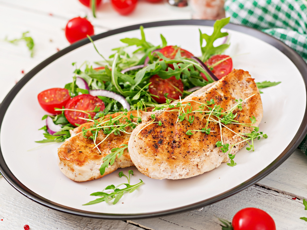 Жареная курица на тарелке с салатом