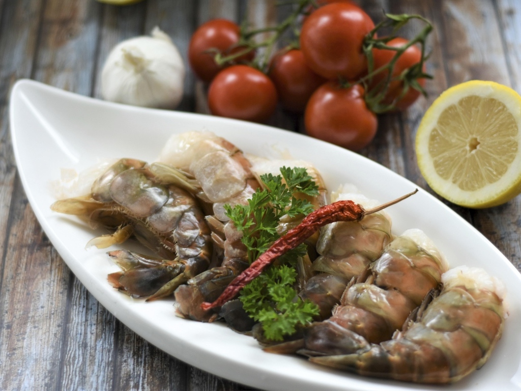 Сырые королевские креветки  на тарелке