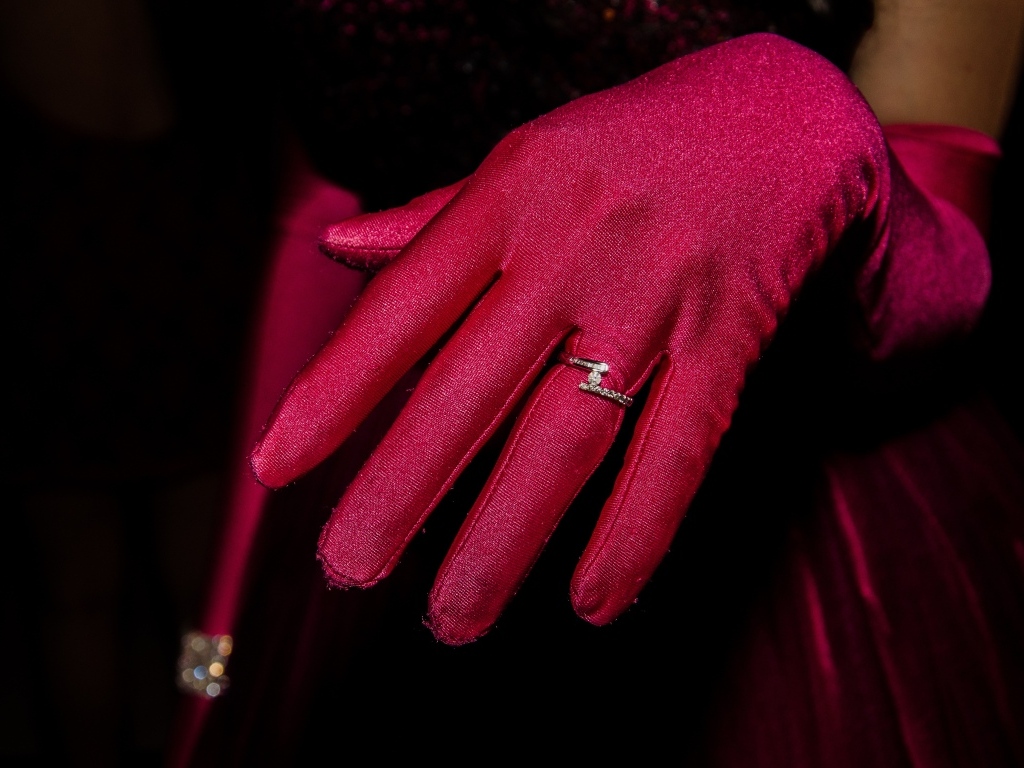 Женская рука с красной перчаткой и кольцом