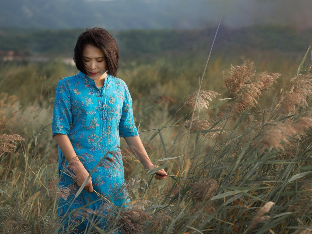 Девушка азиатка в платье на поле с колосьями