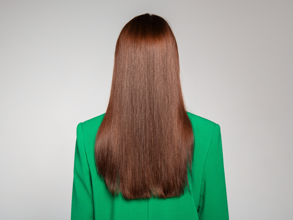 Красивые волосы девушки в зеленом пиджаке