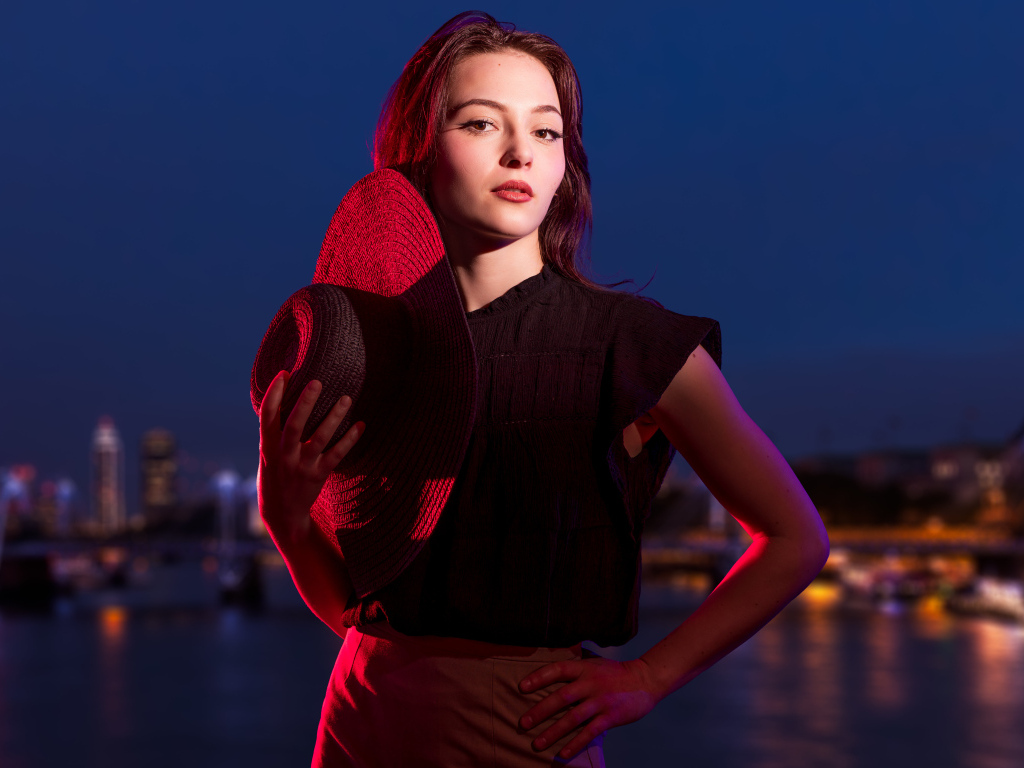 Девушка в лучах света со шляпой в руках