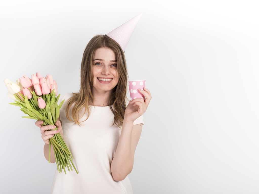 Счастливая девушка с букетом тюльпанов и подарком на день рождения