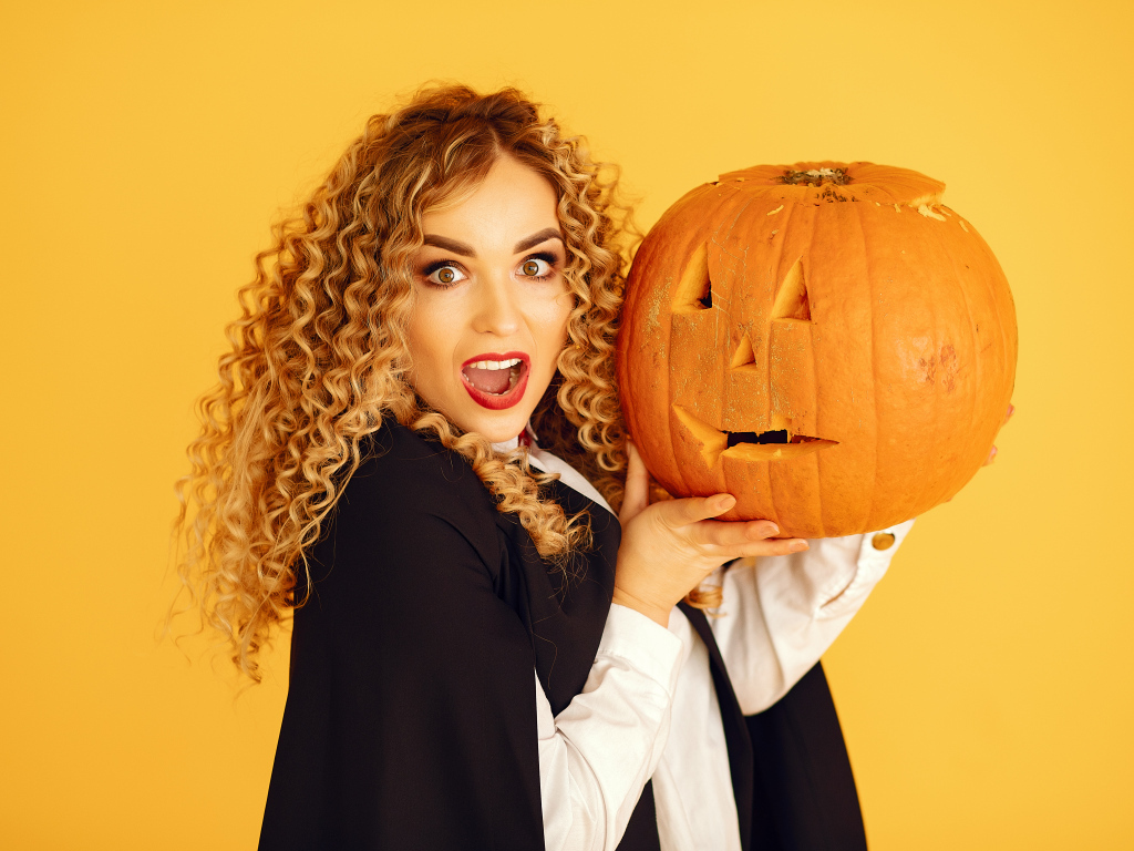 Удивленная девушка с тыквой на Хэллоуин