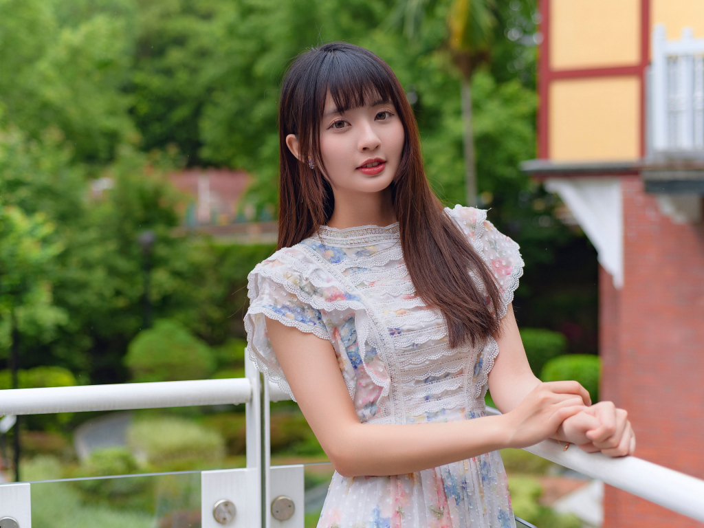 Нежный взгляд молодой длинноволосой азиатки в платье