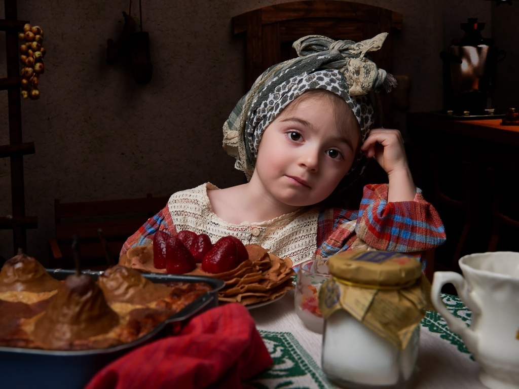 Девочка в платке с угощениями на Масленицу