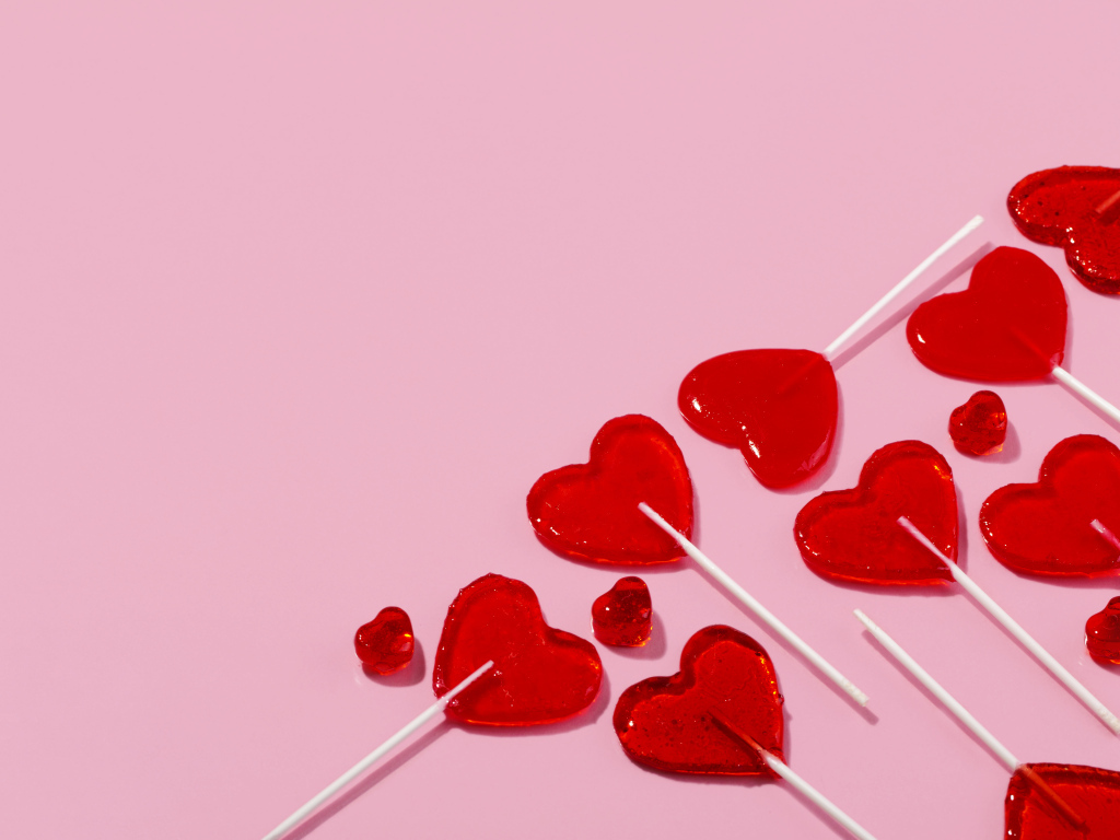 Леденцы в форме сердца на розовом фоне
