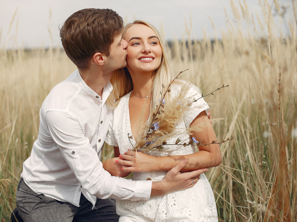 Поцелуй красивой пары на поле