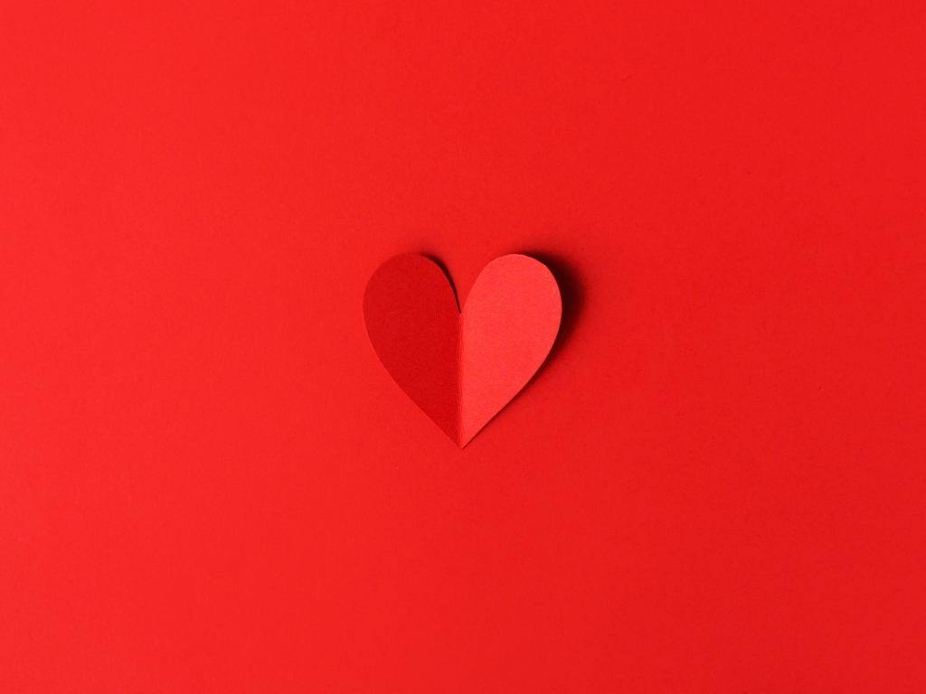 Маленькое бумажное сердце на красном фоне