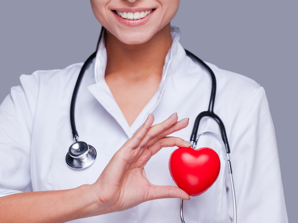 Улыбающаяся женщина врач с красным сердцем